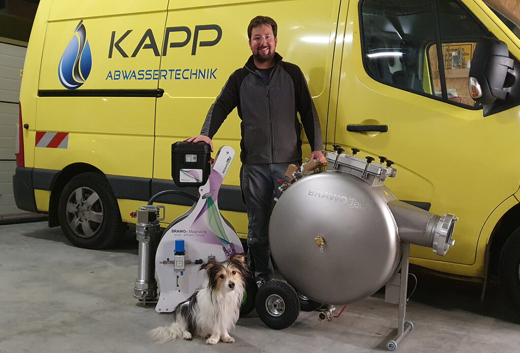 Mann mit Hund vor Servicefahrzeug und Technik zur Kanalsanierung